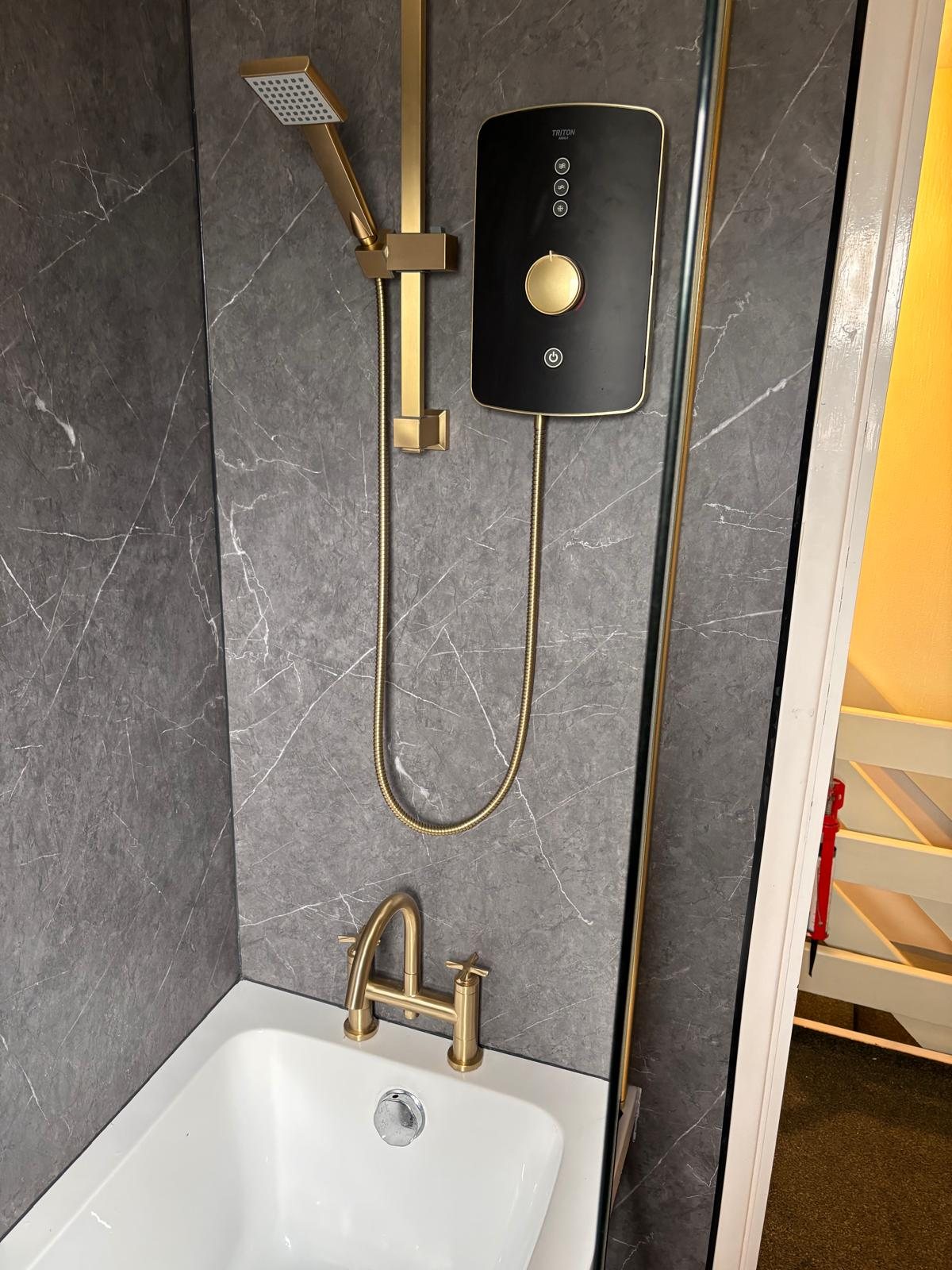 Grey marble bathroom with brushed brass shower fittings, fitted by Inspiring Interiors