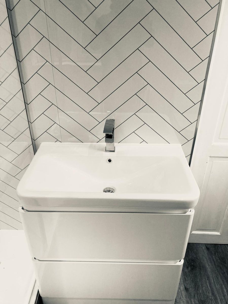 Bright bathroom with herringbone tiling and white vanity unit