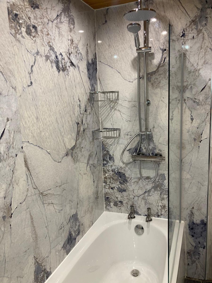 Blue marble effect shower wall with brass shower