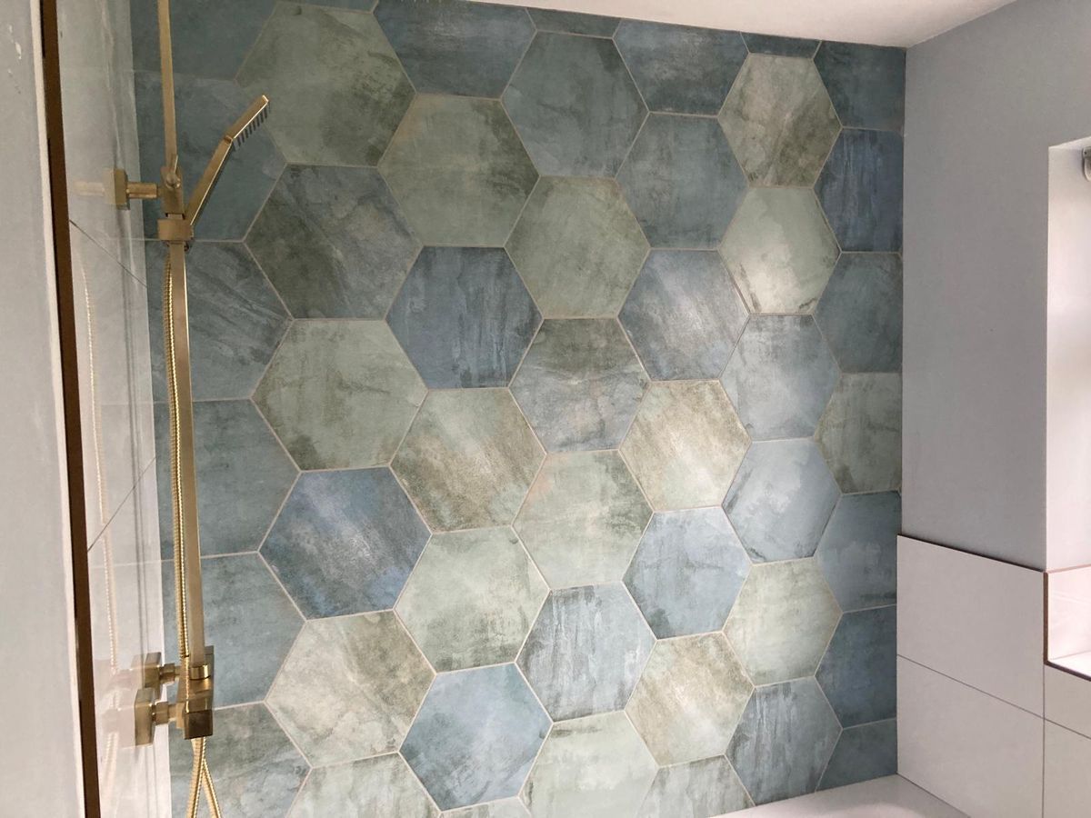 Sage hexagon tiled wall with brass taps