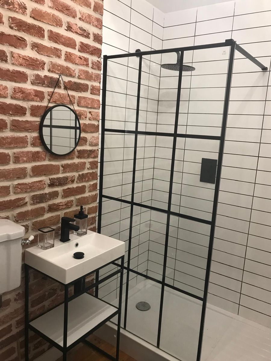 Brick wall bathroom with black framed shower screen